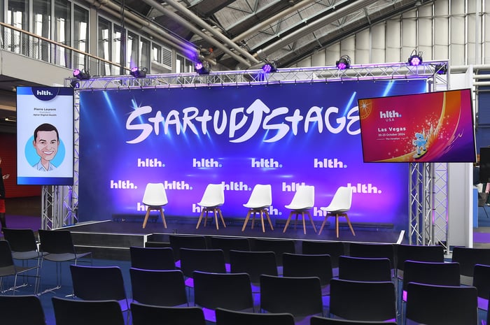 Picture of a GES delivered event stage, featuring on-brand feature area furniture.}