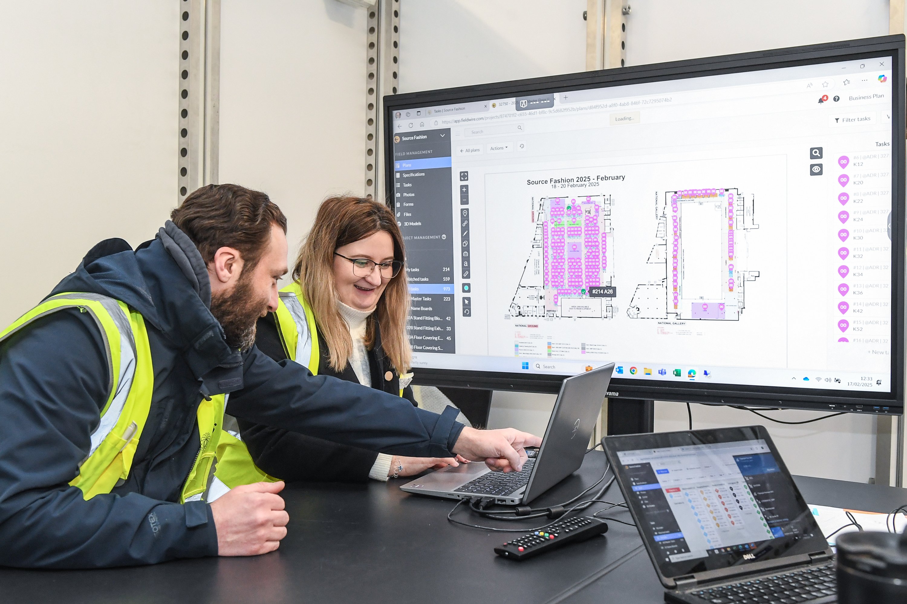 deux membres du personnel de GES consultant le plan d'implantation numérique d'un événement sur leur ordinateur portable.