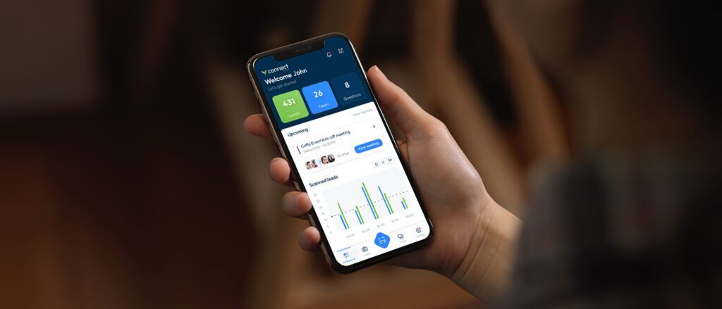 Person holding a smartphone using the Visit by GES event intelligence app, displaying event data and attendee insights on screen.